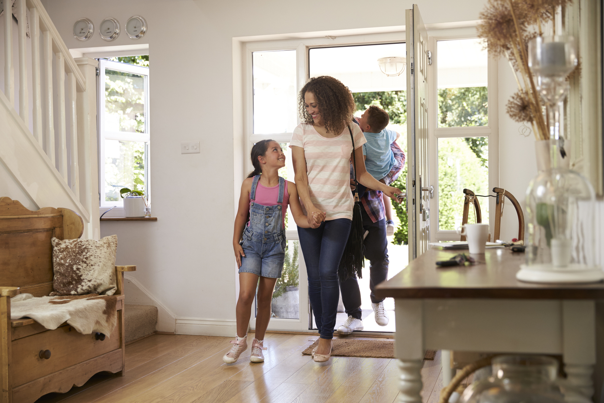 Mother and daughter walking into their home, happy they have protection cover